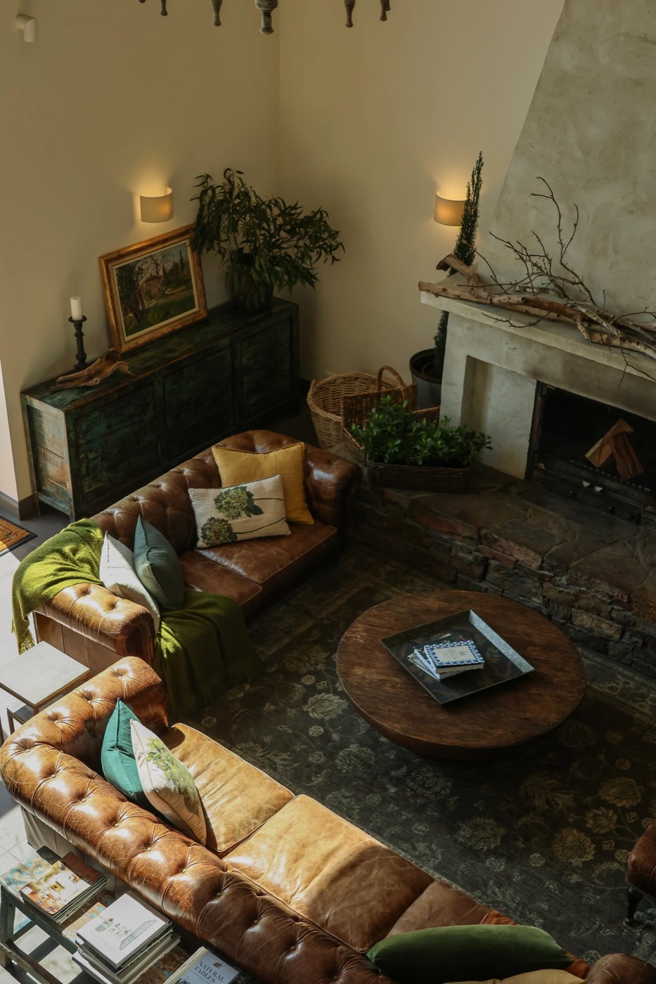 The Farmhouse lounge with leather Chesterfield sofas beside a stone fireplace